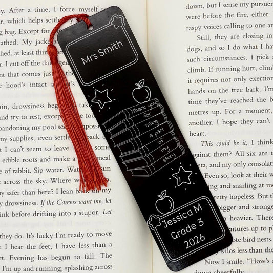 Black Personalised Teacher Gift Metal Bookmark with custom names and thank you message displayed inside an open book
