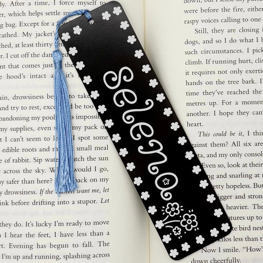 Black Personalised Name Floral Metal Bookmark on open book with light blue tassel