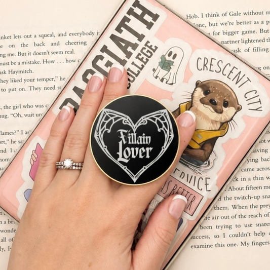 Villain Lover Metal MagSafe Kindle Grip attached to a Kindle and held while reading a book