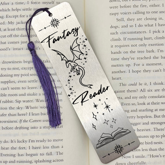 A brushed silver Fantasy Reader Dragon Metal Bookmark on and open book with a purple tassel