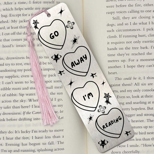 Go Away I’m Reading Metal Bookmark in brushed silver with engraved heart and celestial design on an open book