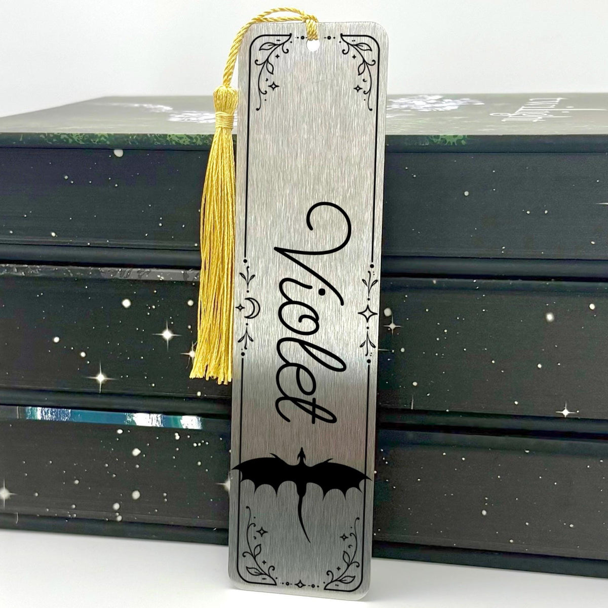     Personalised Name Dragon Bookmark in brushed silver metal featuring the name Violet, dragon design, decorative border and gold tassel.