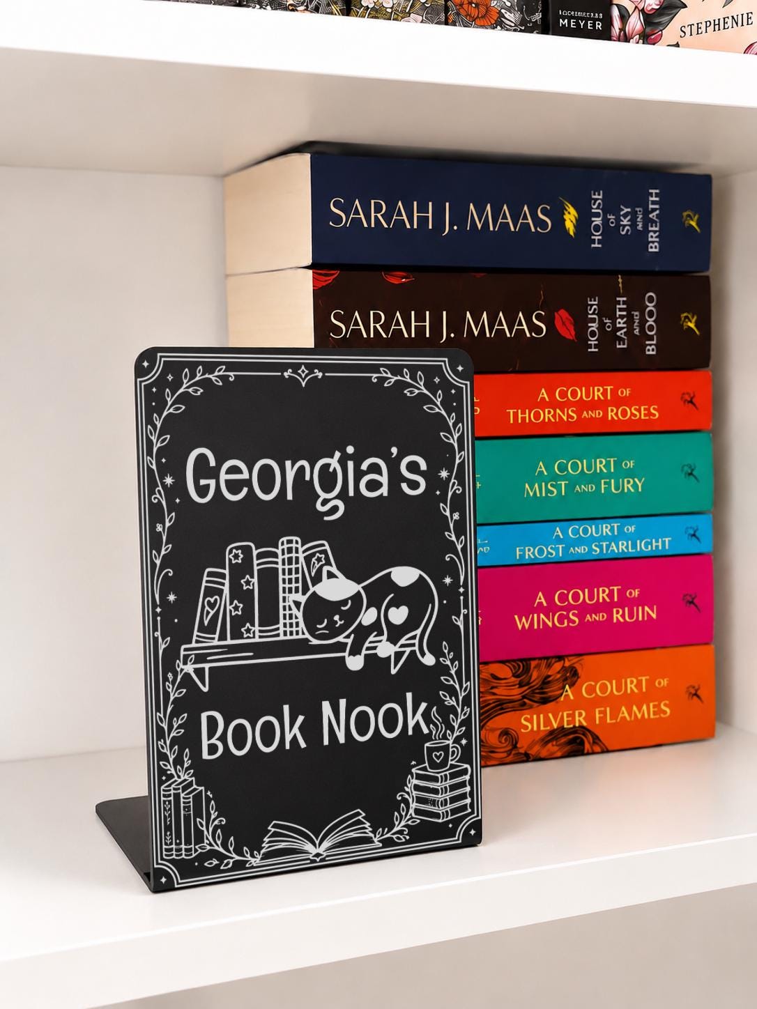     Personalised Name Metal Bookshelf Sign Bookends with custom “Georgia’s Book Nook” engraving, displayed with a colourful stack of fantasy books.