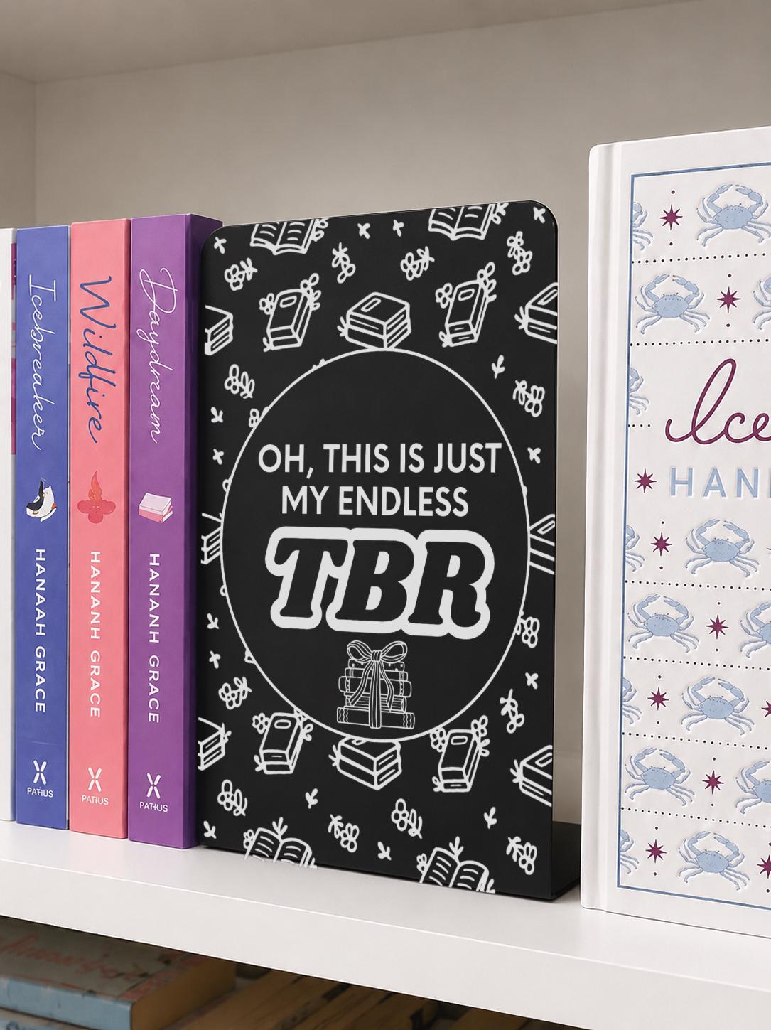     Endless TBR Quote Bookshelf Sign Bookends displayed between books on a white bookshelf, featuring a fun book lover TBR design.