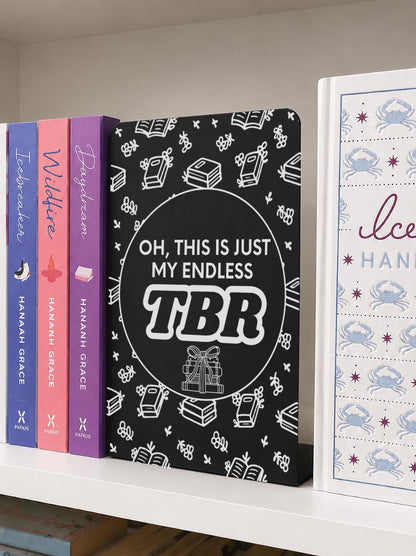     Endless TBR Quote Bookshelf Sign Bookends displayed between books on a white bookshelf, featuring a fun book lover TBR design.