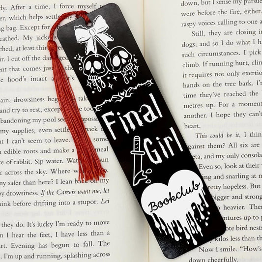     Black Final Girl Slasher Genre Metal Bookmark with red tassel displayed inside an open book.