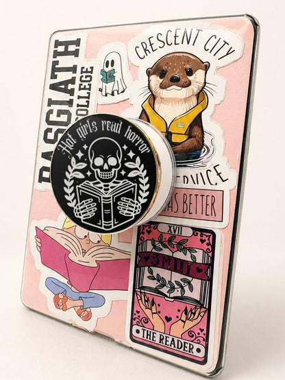     Hot Girls Read Horror Metal Kindle MagSafe Grip featuring a skeleton reading a book, displayed on a decorated e-reader