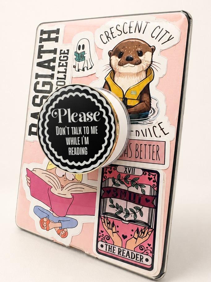     Don’t Talk To Me While I’m Reading Metal Kindle MagSafe Grip attached to a decorated e-reader with bold black and white reading quote design.