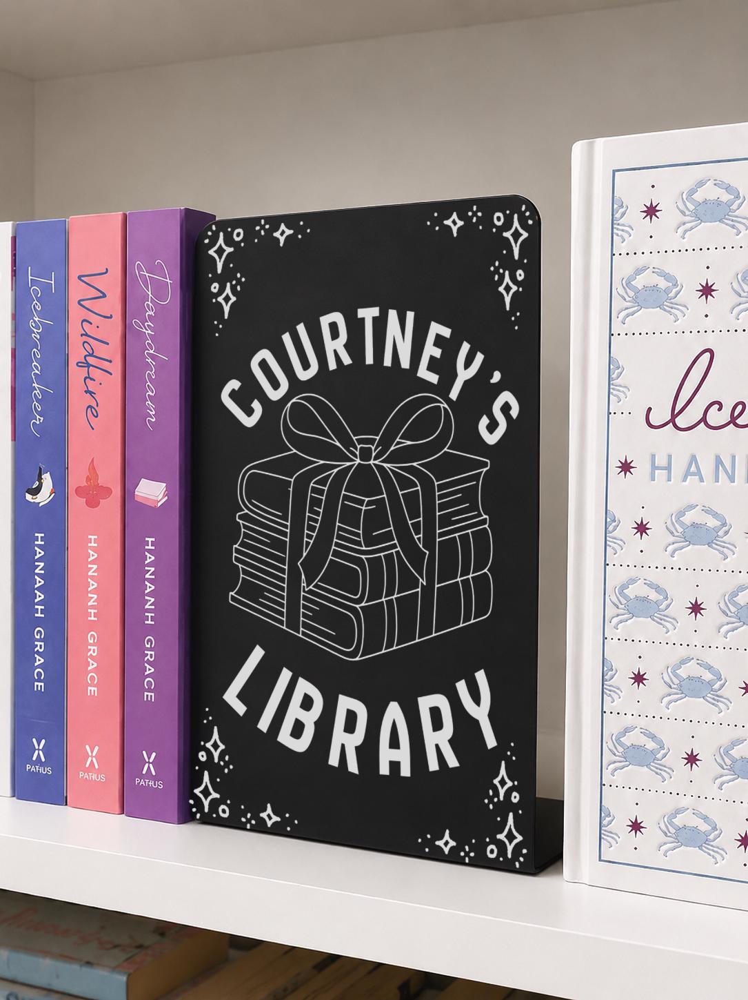     Custom Name Library Metal Bookshelf Sign Bookends in black metal with custom library name and book stack design on a bookshelf