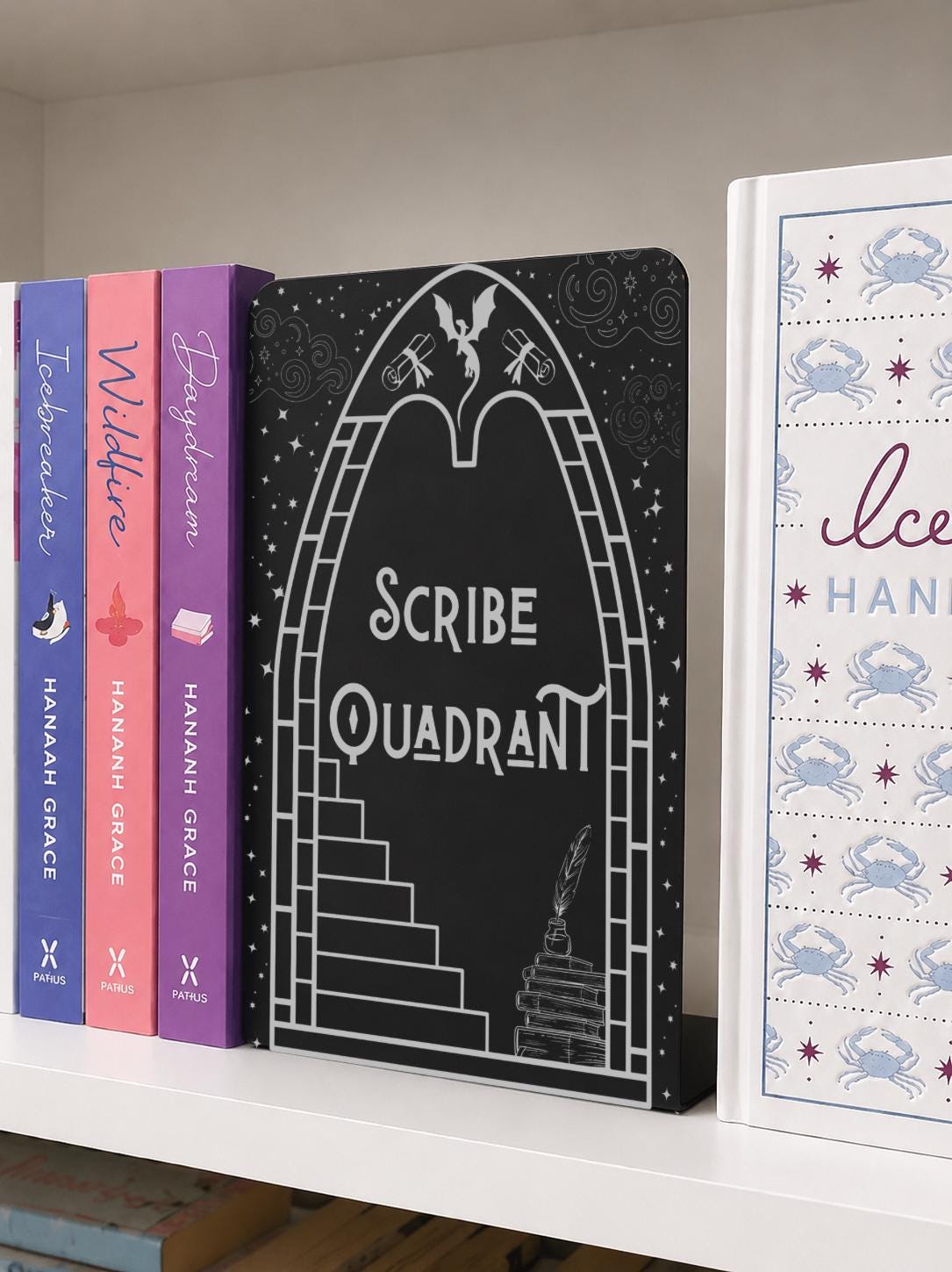     Scribe Quadrant Metal Bookshelf Bookends displayed with fantasy and romance books on a bookshelf