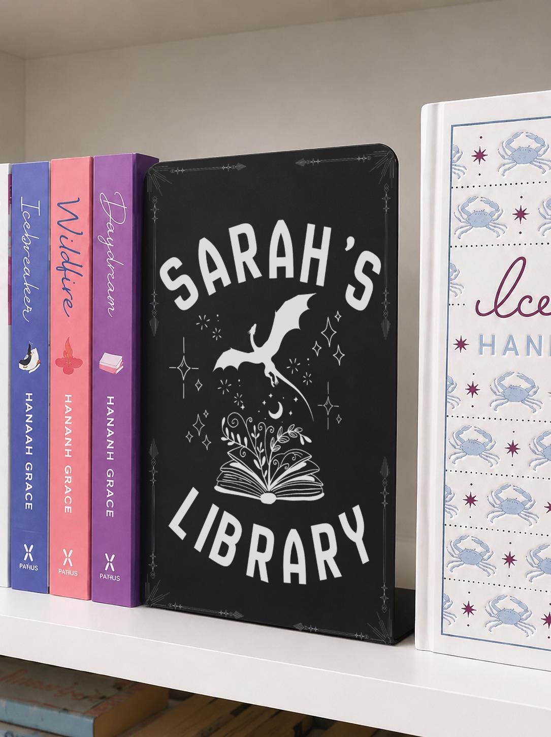     Custom Name Dragon Library Metal Bookshelf Sign displayed between books on a bookshelf
