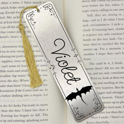     Personalised Name Dragon Bookmark in brushed silver metal with custom name, engraved dragon and decorative celestial border on an open book.