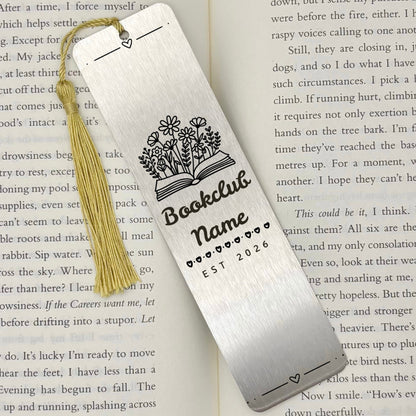 A brushed silver Personalised Book Club Name Metal Bookmark on an open book with a gold tassel
