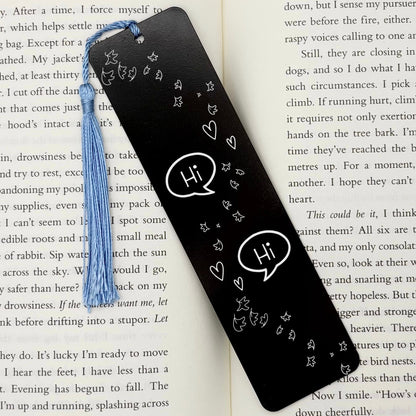     Black Bookish Gay Romance Metal Bookmark displayed inside an open book with blue tassel