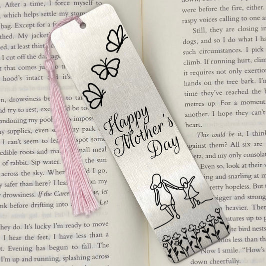 A brushed silver Happy Mothers Day Metal Bookmark on an open book with a pink tassel