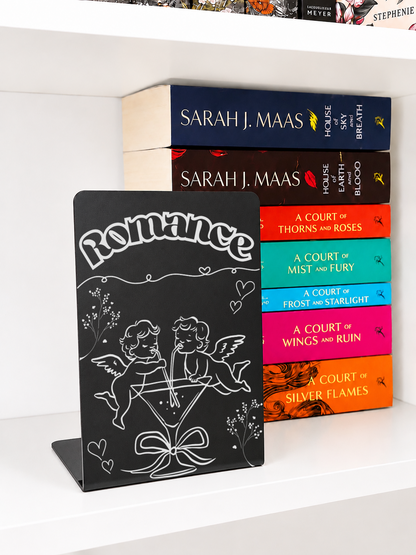     Romance Genre Metal Bookshelf Sign Bookend displayed with a stack of popular romance and fantasy books