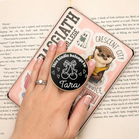     Personalised Name Cherries Metal Kindle Grip attached to a decorated e-reader, personalised with the name Tara.
