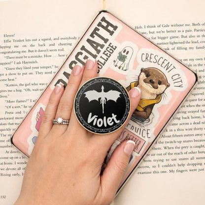     Personalised Name Dragon Metal E-Reader Grip personalised with Violet and shown in hand on an e-reader.