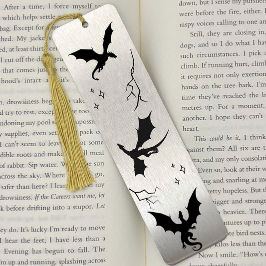 Brushed silver Fantasy Dragons Metal Bookmark with gold tassel on top of an open book