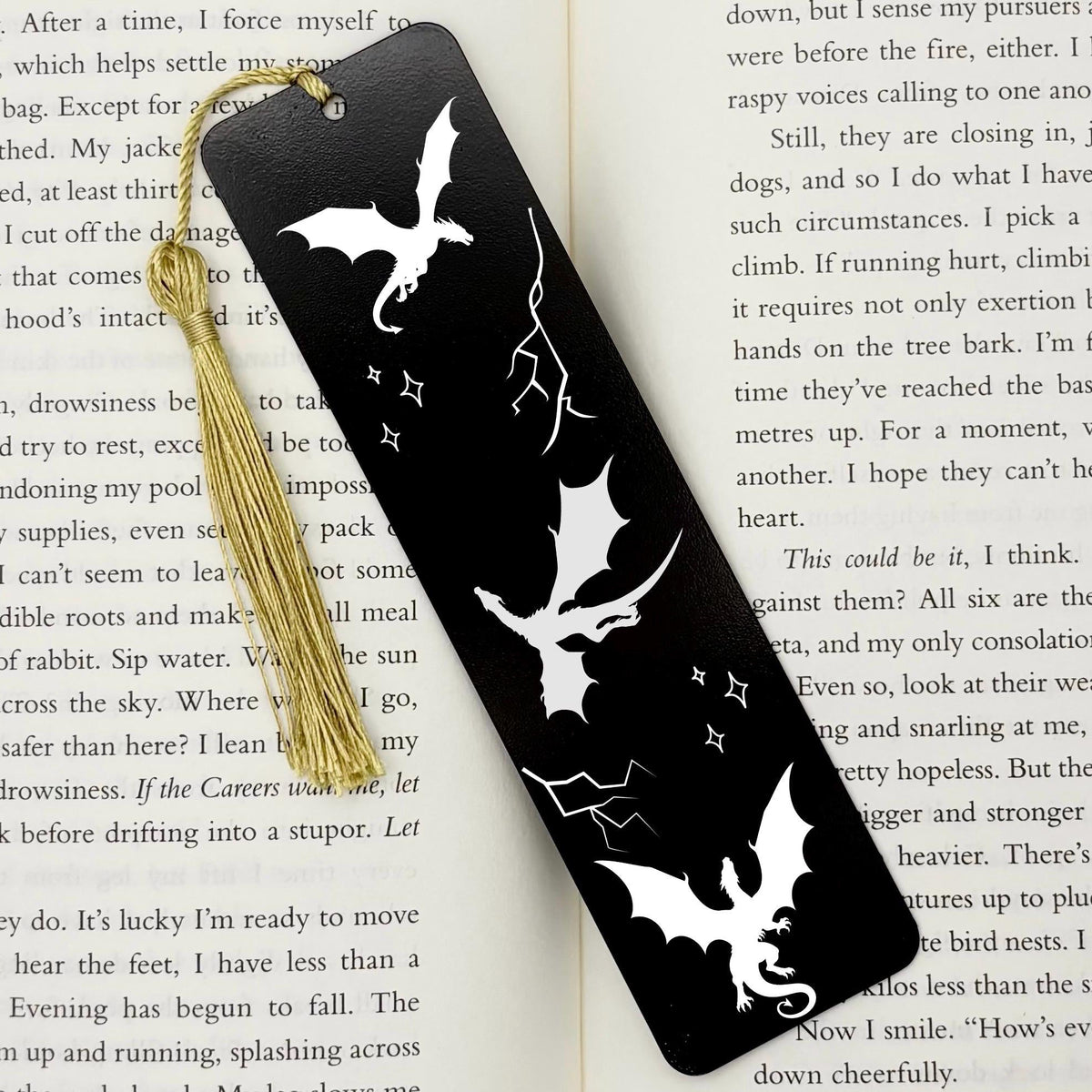 Black Fantasy Dragons Metal Bookmark with gold tassel on top of open book