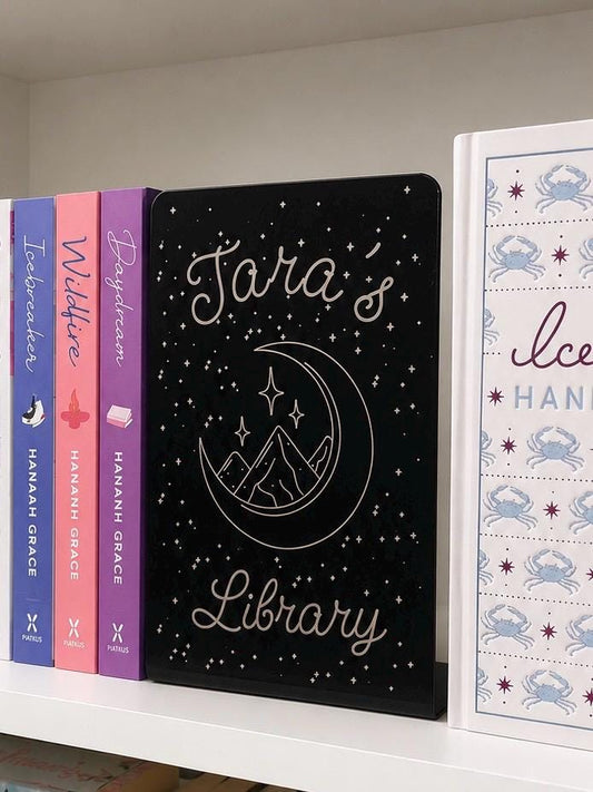     Personalised Name Library Metal Bookshelf Sign Bookends with custom name and celestial design displayed between books