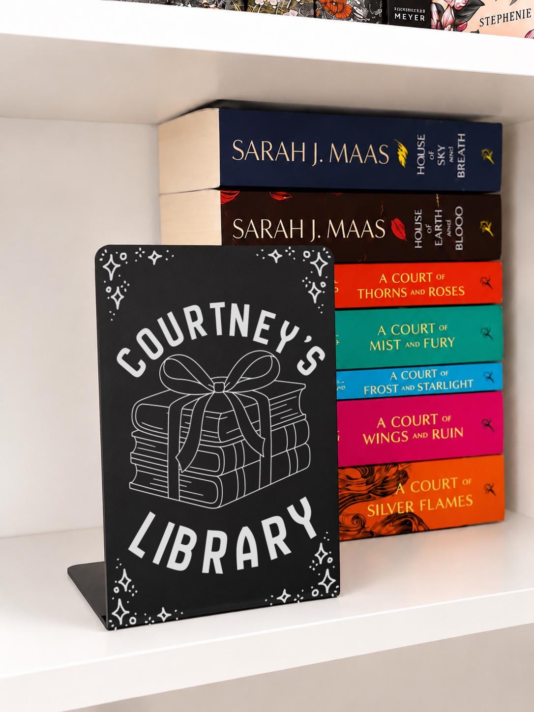     Custom Name Library Metal Bookshelf Sign Bookends in black with personalised library name, stacked books and bow design